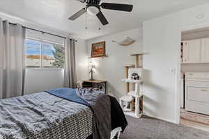 Bedroom featuring carpet flooring, ceiling fan, and washer / dryer