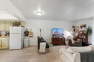 Living room featuring light wood-type flooring and baseboard heating