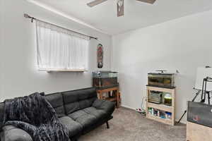 Carpeted living room with ceiling fan