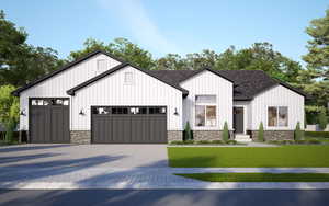 Modern farmhouse featuring a garage and a front lawn