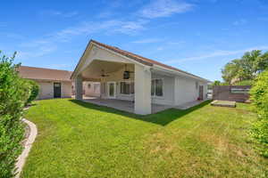 Back of house featuring a yard, ceiling fan, and a patio area