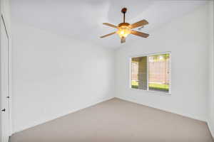 Unfurnished room featuring ceiling fan, light colored carpet, and vaulted ceiling