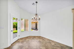 Unfurnished dining area featuring tile patterned floors and a notable chandelier