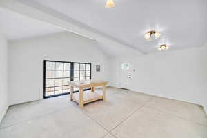 Interior space with lofted ceiling with beams and plenty of natural light