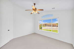 Unfurnished room featuring light colored carpet, vaulted ceiling, and ceiling fan