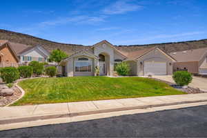 View of front of home featuring a front yard and a garage