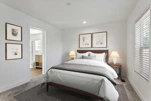 Bedroom featuring ensuite bathroom and light carpet