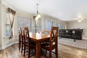 Dining area with wood-type flooring, ceiling fan, and crown molding