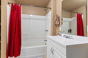 Bathroom featuring tile patterned floors, shower / bathtub combination with curtain, and vanity