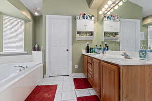 Bathroom with tile patterned floors, vanity, and a bathtub