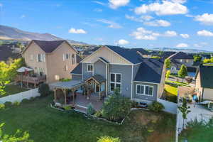 Rear view of house with a deck with mountain view and a lawn