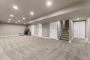 Basement featuring light colored carpet