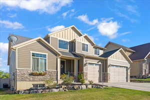 Craftsman-style house featuring a garage, a front yard, and central AC