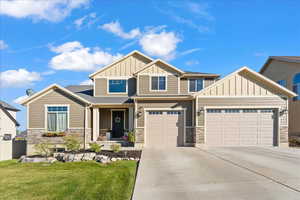 Craftsman house with a front yard and a garage