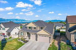 View of front of home with a mountain view and a front yard