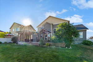 Back of property featuring a lawn and a wooden deck