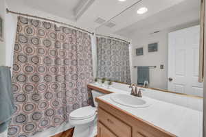 Bathroom featuring walk in shower, vanity, and toilet