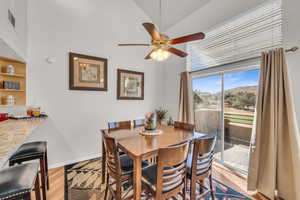 Dining room with ceiling fan, light hardwood / wood-style floors, and lofted ceiling