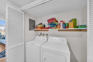 Washroom featuring electric panel, separate washer and dryer, hardwood / wood-style floors, and a textured ceiling