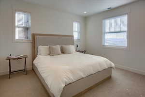 Bedroom featuring light carpet