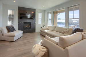 Living room with light hardwood / wood-style flooring and a high end fireplace