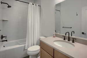 Full bathroom with shower / bath combo, toilet, and vanity