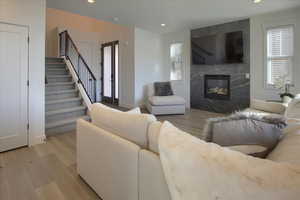 Living room featuring a high end fireplace and light hardwood / wood-style floors