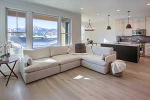 Living room with a mountain view, a chandelier, light hardwood / wood-style flooring, and sink