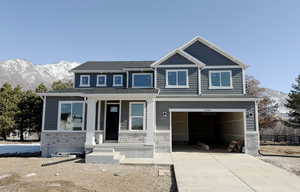 Craftsman inspired home with a garage, a mountain view, and a porch