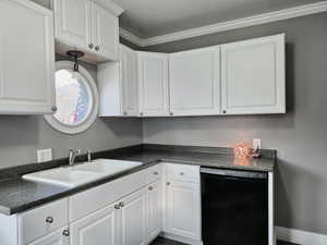 Kitchen featuring white cabinetry, dishwasher, sink, and ornamental molding