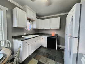 Kitchen with white cabinetry, dishwasher, sink, white refrigerator, and crown molding