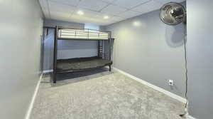 Unfurnished bedroom featuring carpet and a paneled ceiling