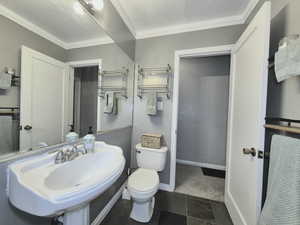 Bathroom with sink, ornamental molding, and toilet