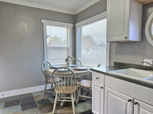 Dining area with crown molding and sink