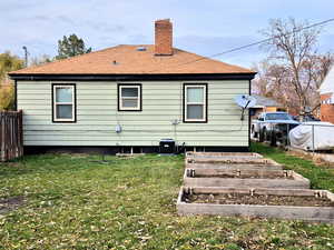 Back of property featuring a lawn and central AC unit