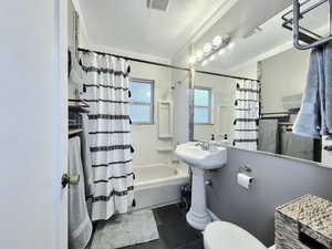 Bathroom with toilet, shower / bath combination with curtain, tile patterned floors, and crown molding