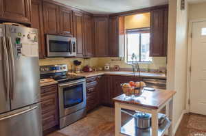 Kitchen with sink, stainless steel appliances, dark hardwood / wood-style flooring, backsplash, and a textured ceiling