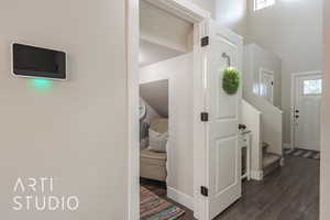 Corridor with a wealth of natural light, a high ceiling, and dark hardwood / wood-style floors