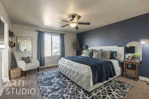 Carpeted bedroom with a textured ceiling and ceiling fan