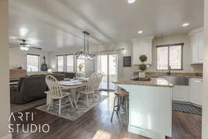 Kitchen with white cabinets, a kitchen island, dark hardwood / wood-style flooring, and hanging light fixtures