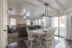 Dining area with a textured ceiling, ceiling fan, a healthy amount of sunlight, and dark hardwood / wood-style floors