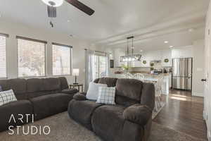 Living room with ceiling fan and dark wood-type flooring