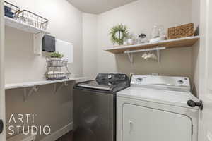 Washroom with wood-type flooring, a textured ceiling, and washer and clothes dryer