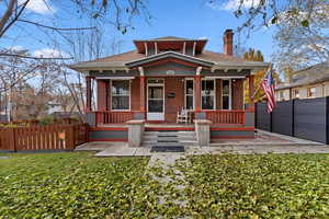 View of front of property with covered porch and a front yard