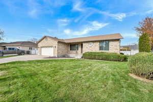 Ranch-style house with a garage and a front lawn