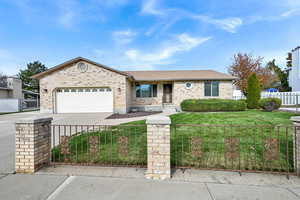 Ranch-style home featuring a front yard and a garage