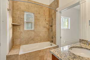 Bathroom featuring vanity and tiled shower / bath