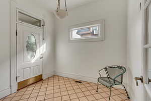 Foyer entrance with light tile patterned floors