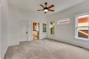 Spare room with light colored carpet, plenty of natural light, and ceiling fan