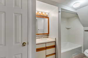 Full bathroom with wood-type flooring, vanity, toilet, and independent shower and bath